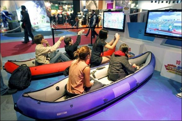 Visitors play a rowing race with Wii games during a visit at the Paris Games Week show in Paris.
