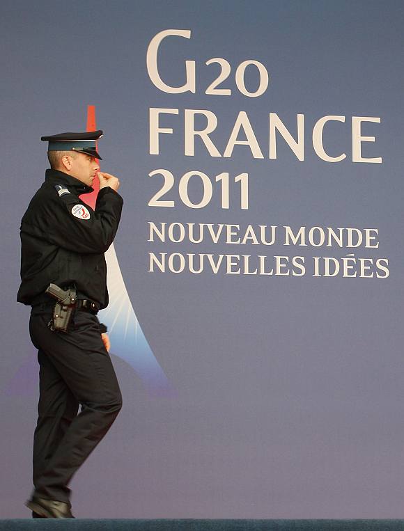 A French police officer walks past the G20 logo and slogan outside the festival palace as preparations for the G20 summit continue in Cannes