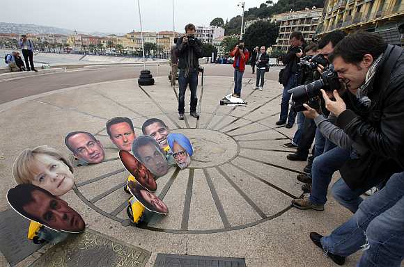 Photographers take photo of masks showing G20 leaders during an anti G20 demonstration to protest against globalisation in Nice