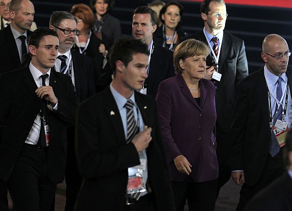 Germany's Chancellor Angela Merkel is surrounded by security as she walks at the G20 venue where world leaders gather in Cannes