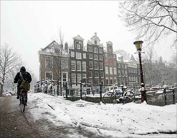 A cyclist makes his way over a snow covered bridge in the Dutch capital of Amsterdam.