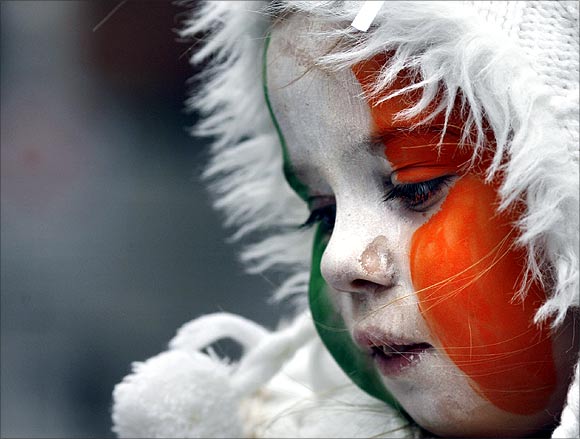 A girl with face paint in Irish national colours looks on during the Saint Patrick's Day parade along Dublin's city centre.