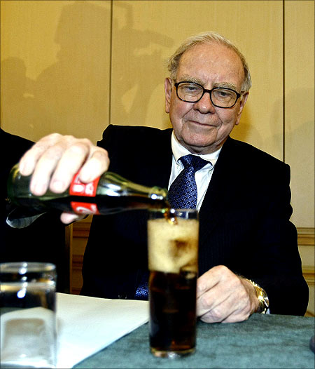 Warren Buffett fills a glass with Coke.