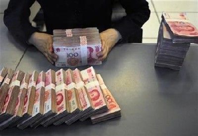 A Chinese bank teller counts currency.