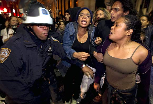Sade Adona (R) yells as fellow members of the Occupy Wall Street movement clash with New York Police Department officers after being removed from Zuccotti Park in New York.