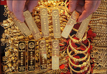 A shopkeeper shows gold bars in Bangkok's Chinatown.