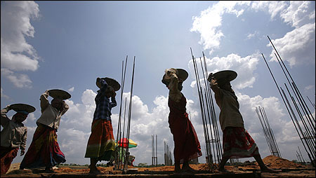 Women labourers work at the construction site of a commercial complex.