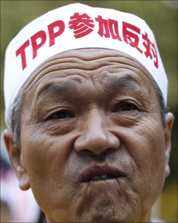 A farmer attends a rally as he wears a sign reading 'against participating in TPP' in Tokyo.