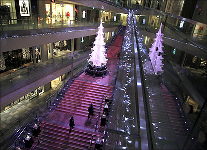 A couple walks towards a Christmas tree at a shopping mall in Tokyo.