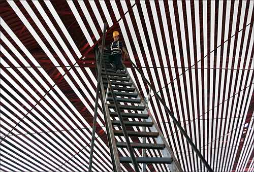 A worker walks downs a ladder from the roof of the new terminal of Beijing's International Airport.