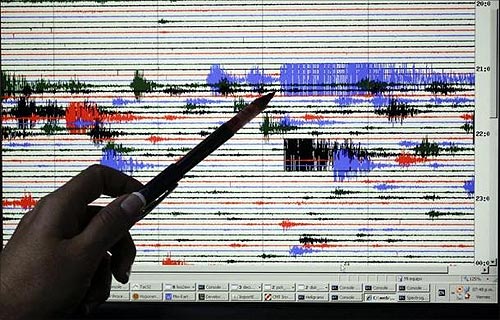A staff at the National System of Territorial Studies (SNET) points at a screen showing brief quakes.