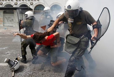 Policemen drag a protestor in Athens, Greece.