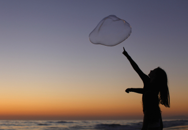 A girl plays with a giant bubble as the sun sets at Moonlight Beach in Encinitas, California.