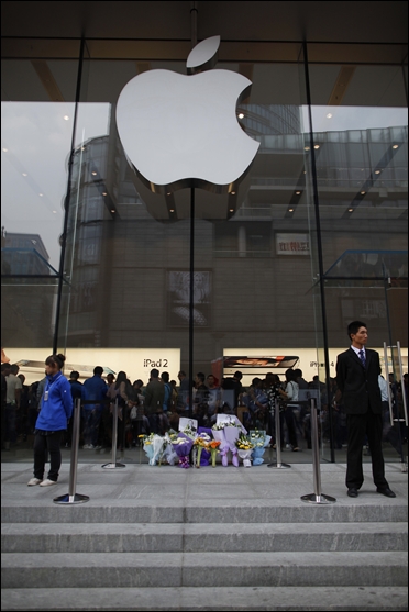 Flowers in memory of Apple co-founder Steve Jobs are placed outside an Apple Store in downtown Shanghai.