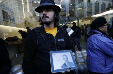 Software developer Steve Streza displays a photograph of Jobs outside the Apple Store in San Francisco, California.