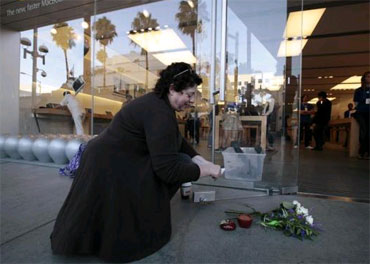 Janine Young, 53, lights an apple-shaped candle for Jobs outside an Apple Store in Santa Monica, California.