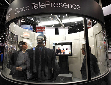 People stand inside a Cisco TelePresence conference room at the National Retail Federation Annual Convention.
