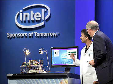 Intel CEO Paul Otellini looks over a prototype solar-powered computer.