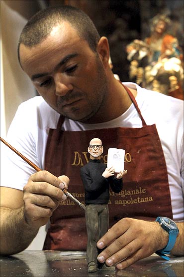 Artist Gennaro Di Virgilio paints a figure of Apple founder Steve Jobs in his shop in Naples.