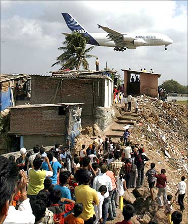 People watch an Airbus A380 aircraft land at Mumbai airport.