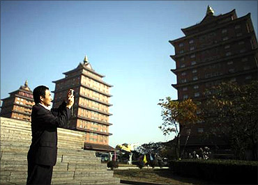 A man takes pictures in Huaxi village.