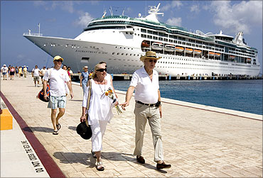 Tourists walk beside Royal Caribbean's cruise ship after they arrive in Cozumel, Mexico.