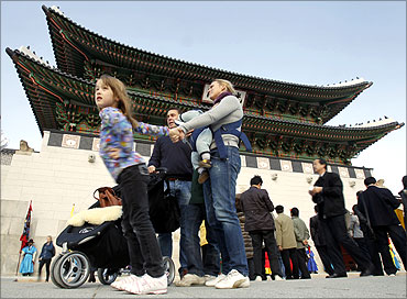 Foreign visitors stand in front of the Gwanghwamun, main gate of the royal Gyeongbok Palace, in Seoul.
