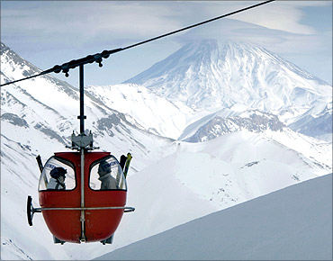 A tele-cabin moves along a rail as Iran's Mount Damavand is seen at the background at Dizin ski slope north of Tehran.