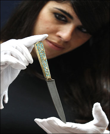 A gold and turquoise-hilted knife.
