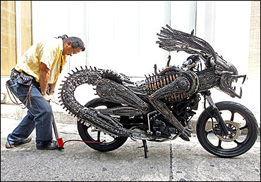 Sangwongprisarn inflates air into the rear tyre of a motorcycle.