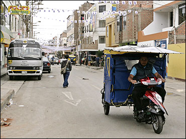 A student test drives a motorised rickshaw running on solar energy on the streets of Lima.