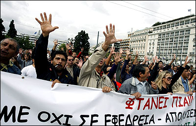 Protesters raise their hands to the parliament in an offensive gesture during an anti-austerity rally in Athens.