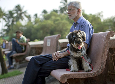 Mohan Silva sits on a park bench in the evening with his eight-month-old specially bred miniature schanuzer, Smokey in Mumbai.