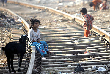 A girl sits on a rail track.