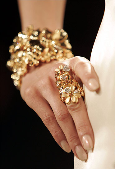 A model poses wearing gold jewellery.