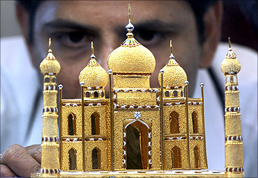 A worker displays a miniature 22 carat gold replica of Taj Mahal in Chennai.