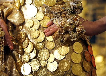 A model in a golden dress decorated with 325 Austrian gold coins, poses for photographers.