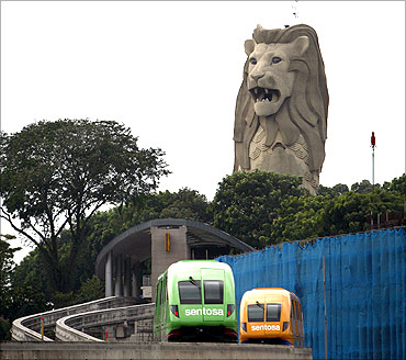 Monorail vehicles pass in front of the Merlion statue on Singapore's Sentosa Island.