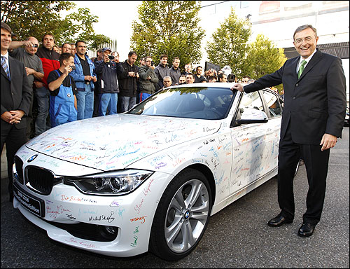 Chief Executive of German luxury carmaker BMW Norbert Reithofer poses next to BMW 320d sedan.