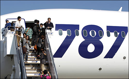 Passengers take pictures as they board the plane at Narita airport in Narita, east of Tokyo.