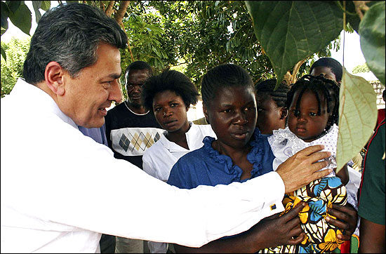 Rajat Gupta greets a child at a clinic in Lusaka.