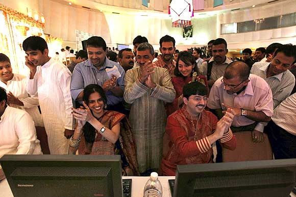 tockbrokers cheer as they trade at their terminals at the Bombay Stock Exchange.