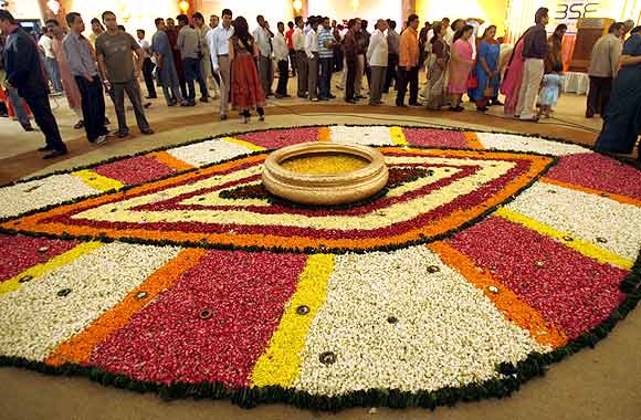 People stand beside a flower decoration during a special trading session on the occasion of the Hindu festival of Diwali.