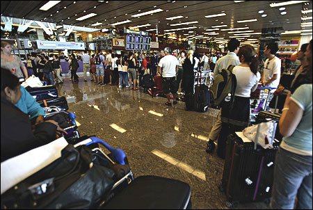 Stranded Qantas passengers line up as they seek alternative travel arrangements at Singapore's Changi Airport.