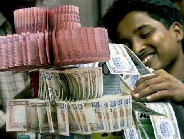 A Bangladeshi currency vendor displays fresh notes for clients in Dhaka.