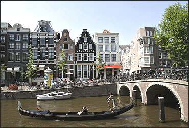 A woman rows her gondola through the canals of central Amsterdam.