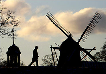 A man walks past a windmill in Kastellet park in Copenhagen.