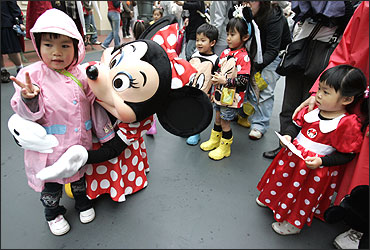 A Japanese girl poses with Disney character Minnie Mouse at Tokyo Disneyland.