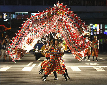 Participants perform a dragon dance during a Hungry Ghost Festival parade along the streets of Keelung, northern Taiwan.
