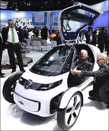 Visitors look at the German car manufacturer Volkswagen' concept car Nils.